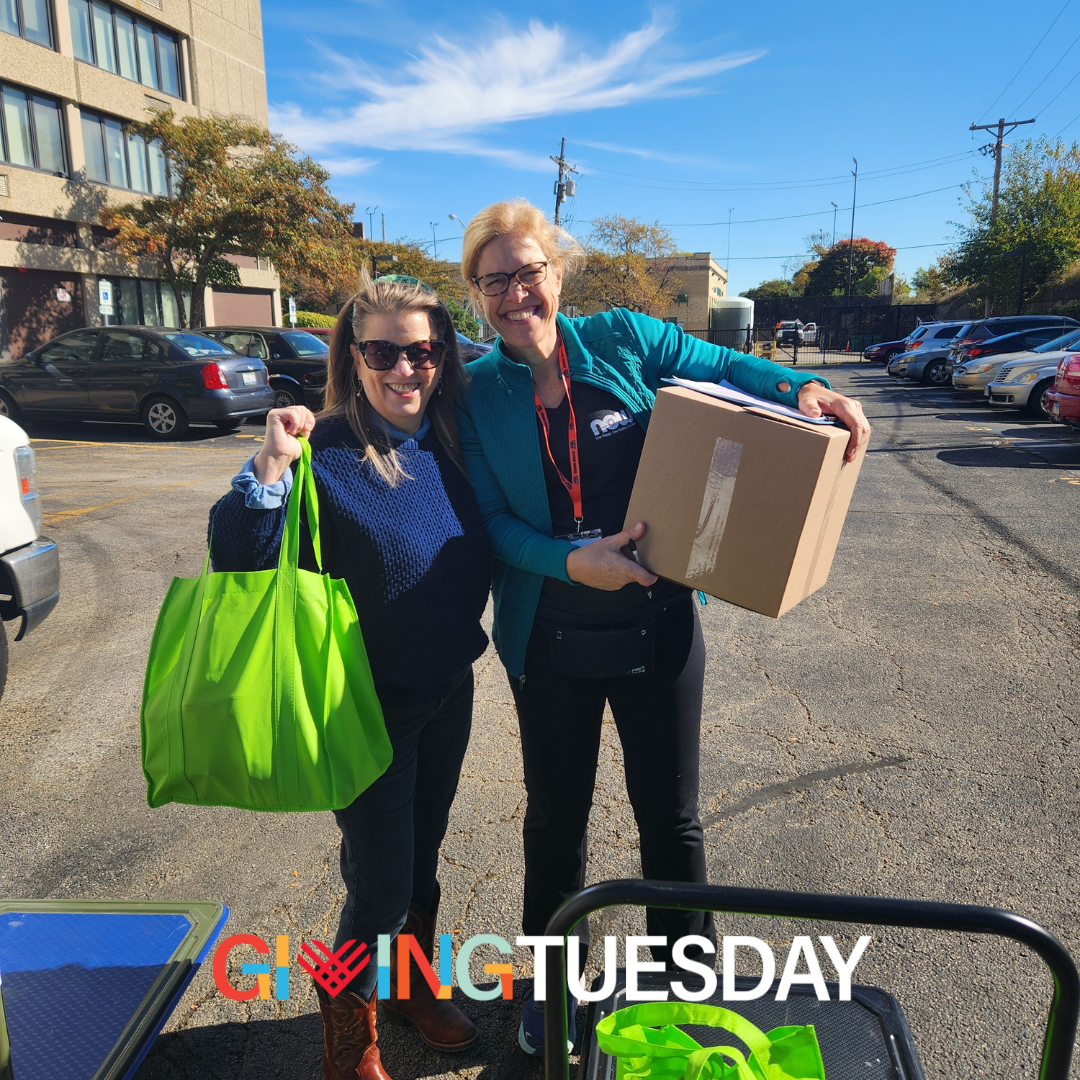 An image of two women, one holding a bag of groceries and the other a box of groceries. Text at the bottom of the image reads "Giving Tuesday"