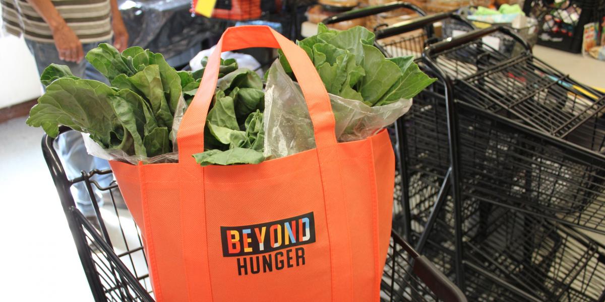 Beyond Hunger grocery bag filled with greens inside a shopping cart
