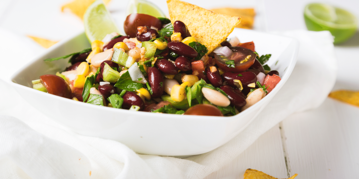 Cowboy Caviar with tortilla chips in white serving ware