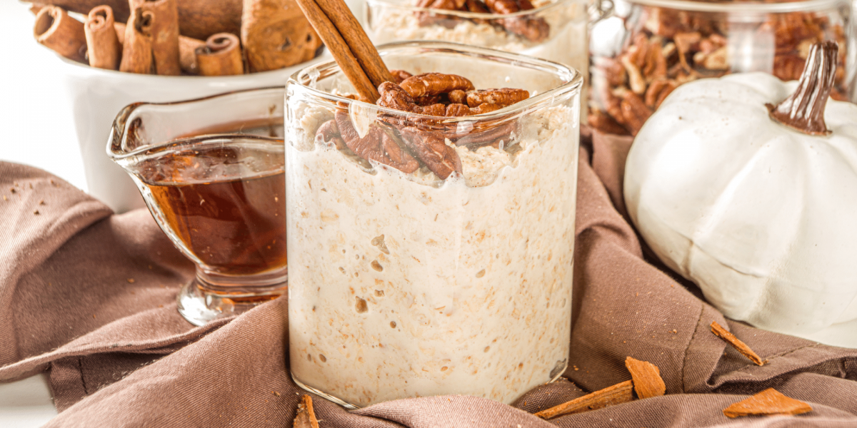 overnight oats with cinnamon and pecan garnish maple syrup in background