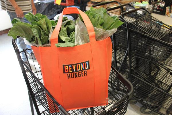 Beyond Hunger grocery bag filled with greens inside a shopping cart